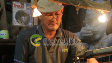 Pengusaha bernama lengkap eddy roostopo ini tengah serius menggergaji balok bambu sebagai bahan dasar membuat busur panah