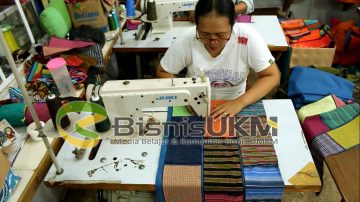 Seorang karyawan tengah menjahit kain perca batik warna-warni. Pemilihan warna juga diperhatikan agar sesuai mode dan keinginan masyarakat saat ini.
